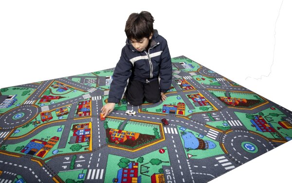 Kind spielt auf einer Verkehrsmatte mit Straßen und Häusern, fördert Verkehrserziehung und Koordination.