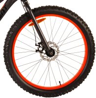 Schönes schwarzes Fahrrad mit roten und orangen Felgenakzenten