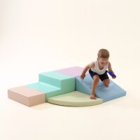 Kind spielt auf bunten, gepolsterten Spielmodulen in verschiedenen Formen