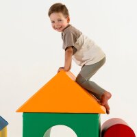 Junge klettert auf ein buntes Spielhaus aus Schaumstoff