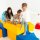 Kinder spielen auf bunten, geometrischen Spielblöcken in verschiedenen Farben