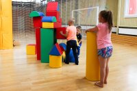 Kinder spielen mit bunten Bauklötzen in einem Innenraum