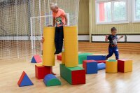 Kinder spielen mit bunten Bauklötzen in einem Innenraum