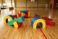Bunte Schaumstoffspielgeräte in einer Sporthalle auf Holzfußboden