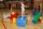 Kinder spielen auf bunten Bewegungsbausteinen in einer Sporthalle