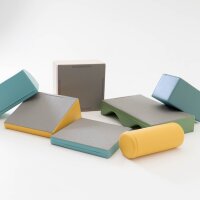 Bunte Yogahilfen in verschiedenen Formen und Größen auf hellem Hintergrund