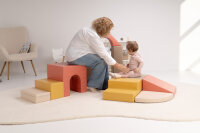 Zwei Kinder spielen mit weißen Bauklötzen in einem Spielzimmer