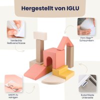 Drei Kinder spielen mit Bauklötzen und einem Buch auf einem Teppich