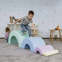 Junge krabbelt durch bunte Schaumstoffspielgeräte in einem Spielzimmer