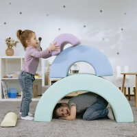 Kind spielt auf bunten Schaumstoffspielgeräten in einem Spielzimmer