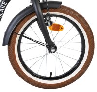 Vorderreifen eines Fahrrads mit braunem Profil und reflektierendem Element