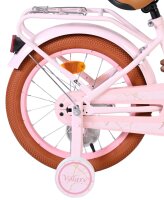 Rosa Fahrrad mit braunem Reifen und reflektierendem...