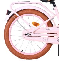 Rosa Fahrrad mit braunem Reifen und reflektierendem...