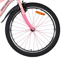 Vorderreifen eines Fahrrads mit pinkem Rahmen und reflektierendem Element