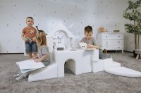 Kinder spielen mit modularen Bausteinen in einem hellen Raum