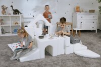 Kinder spielen mit modularen Bausteinen in einem hellen Raum