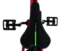 Schwarzer Fahrradsattel mit grüner Linie und Pedalen im Hintergrund