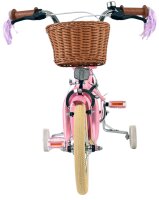 Rosa Kinderfahrrad mit Korb und braunen Griffen von vorne betrachtet