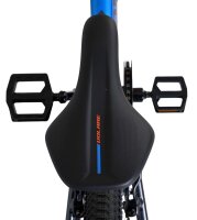Schwarzer Fahrradsattel mit blauen Akzenten und Pedalen im Hintergrund