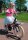 Mädchen fährt auf einem Fahrrad mit pinkem Rock und glitzerndem Oberteil