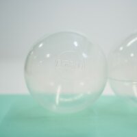 Transparente Kunststoffkugeln auf einer grünen...