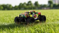 Blij´r Beast rot RC Monstertruck fährt auf einer Wiese